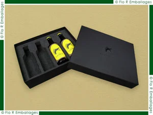 Packaging en carton compact habillé de papier noir mat intérieur et extérieur, sublimé par un marquage à chaud noir créant un effet discret et élégant ton sur ton. Un calage en mousse noire est intégré afin de maintenir parfaitement quatre bouteilles en verre